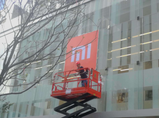 试营业前一天，正在将小米的LOGO挂到玻璃墙面上去