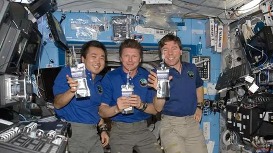  国际空间站宇航员正在快乐的引用由尿液净化得到的纯净水。（图片来源：NASA）