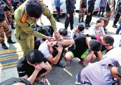 老挝警方给犯罪嫌疑人打开手铐,准备登机。 大河报 图