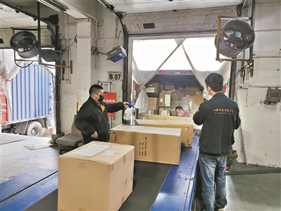 邮政工作人员对进口快件进行消毒把关，图源广州日报