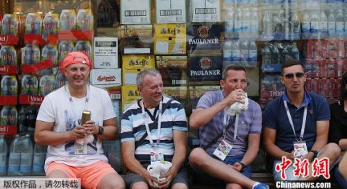 资料图：世界杯球迷喝酒观赛。