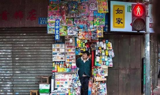 ▲广州市荔湾区长寿东路，一家只能容纳一人的小小士多店。摄于2017年3月25日。图片来源：中国摄影家协会网。