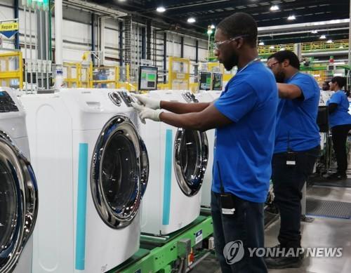 三星电子美国工厂内，一名美国工人正在检查洗衣机（图片来自韩联社网站）