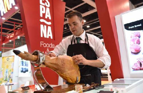 5月9日，来自西班牙的参展人员在亚洲国际食品及餐饮设备展现场展示西班牙火腿切片。（新华社）