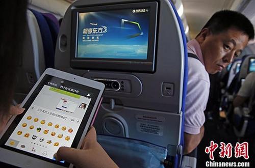 资料图为旅客在东航实际承运的航班上使用平板电脑（Pad），进行空地互联微信聊天。 中新社记者 殷立勤 摄