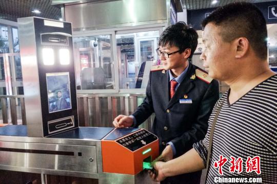 图为铁路工作人员指导旅客“刷脸”进站。　王丹惠　摄