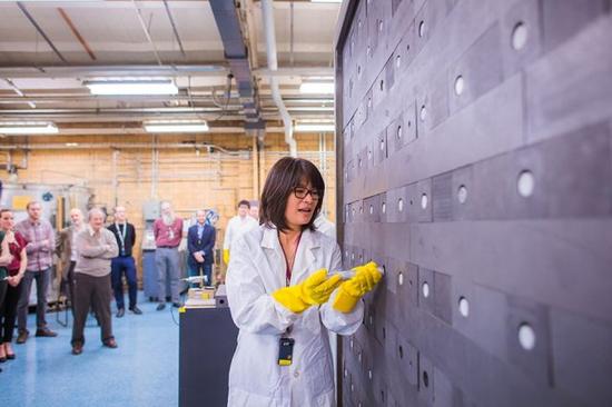 图 | 高级研究员胡玲文将燃料棒装载到 MIT 石墨指数堆的燃料通道内。