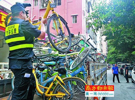 执法人员清理乱停放的共享单车。