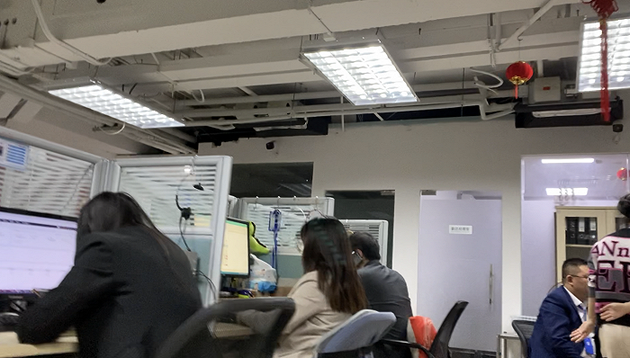 公司里,每一位催收员都背负着考核压力,几乎全天候带着耳麦。王飞翔摄
