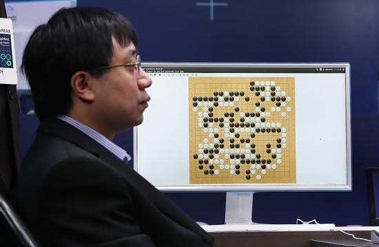 图注:代替AlphaGo执子的黄士杰冷静得像是工厂里的操作员