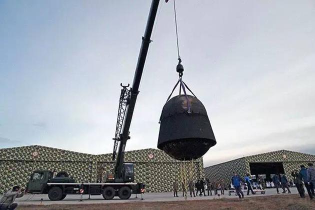 经过12天太空飞行之后返回地面的实践十号返回舱，被科研人员翻转吊起。图片来源：本文作者
