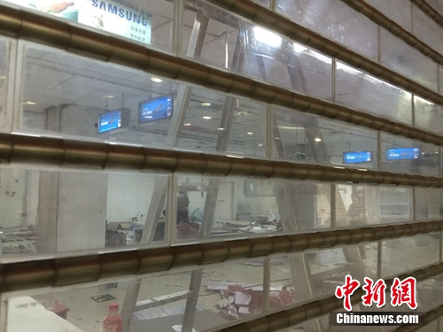 石家庄海龙电子城 海龙电子城1楼,透过闸门,可以看到有人在整理现场。中新网 吴涛 摄