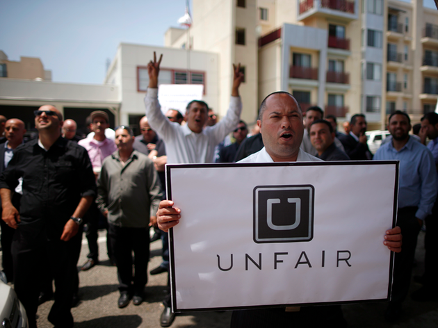 Uber司机举行抗议活动，一名司机举着“Uber不公平”的标语