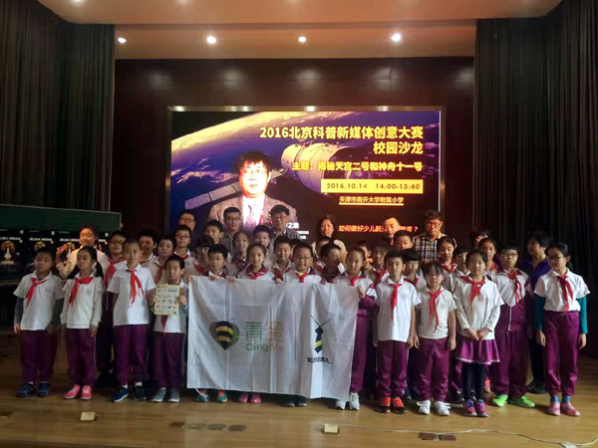 南开大学附属小学的同学和老师们手持青蜜社团经理人的旗帜与航天专家合影