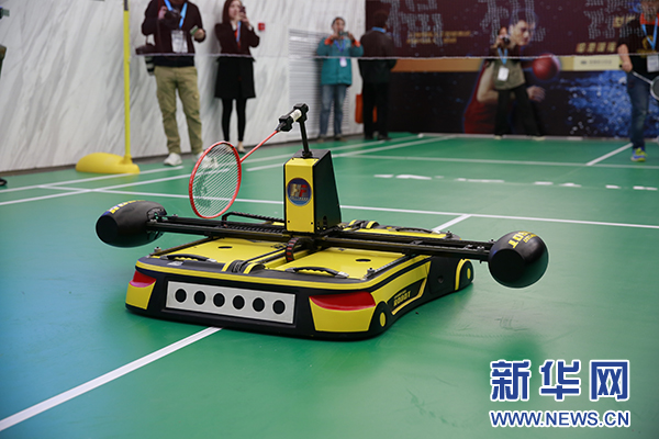 展区内，羽毛球机器人在与工作人员演示羽毛球比赛。（新华网 鲁聃玉文摄）