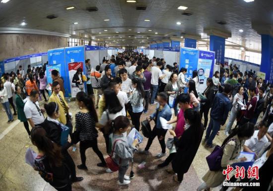 资料图：应聘者排队等待。中新社记者 李进红 摄