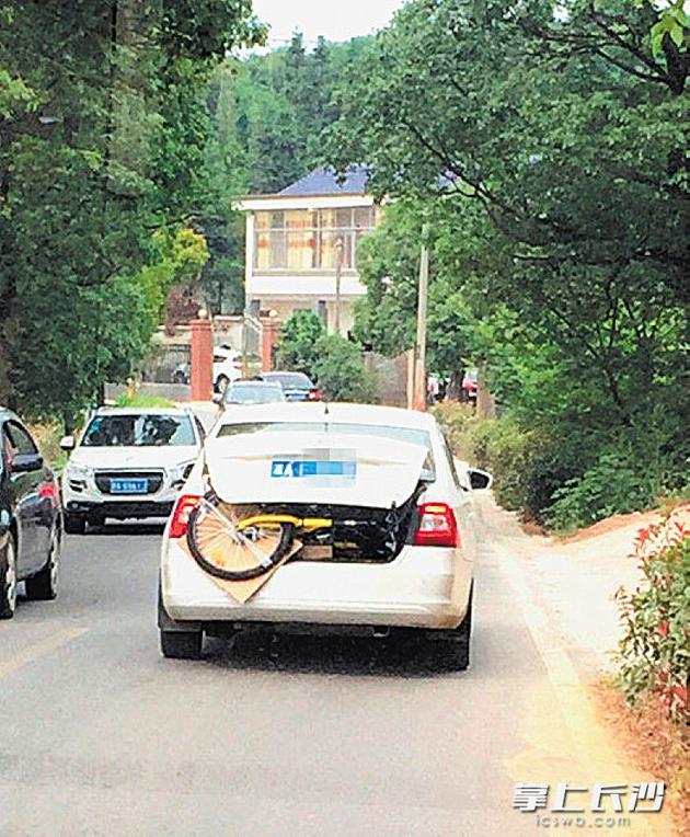 一輛斯柯達轎車拖著ofo小黃車，行駛在寧鄉的鄉間道路上。 均為網友供圖