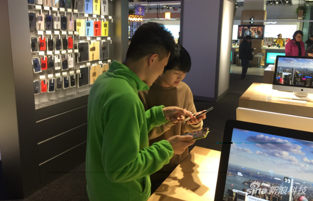 图:顾客正在苏宁门店内接受苹果产品设置服务的帮助