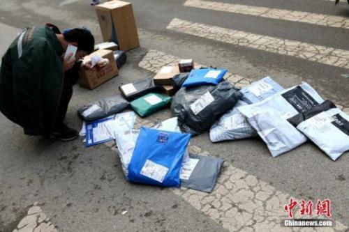 面单是什么:快递公司搞的隐私面单是什么?让你不再手撕快递单 资料图:快递员在打电话联系收快递者。中新社记者 张远 摄