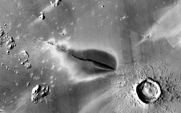 在科柏洛斯槽沟地区，延伸到裂缝两侧的黑色斑点标志着火星近期存在火山活动。直径约13公里。图片来源：NASA/JPL/MSSS/The Murray Lab。
