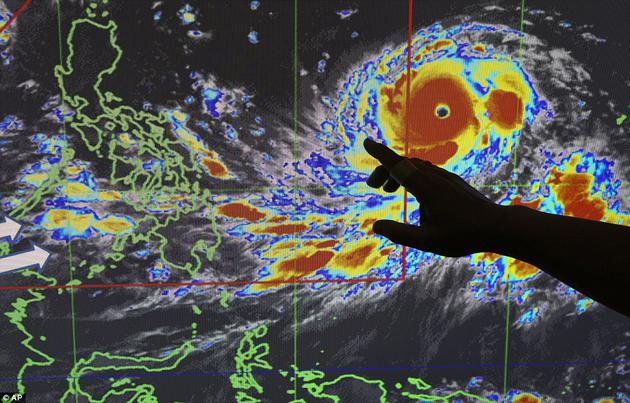 菲律宾气候员美诺•门多萨(Meno Mendoza)演示了台风“山竹”的侵袭路径，其持续风速为每小时127英里，风速最高达到每小时158英里。