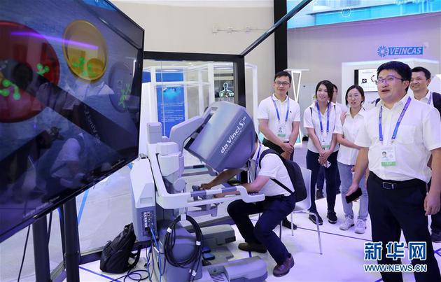9月17日，参观者在大会现场观看一个机器人手术系统的作业演示。新华社记者 方喆 摄