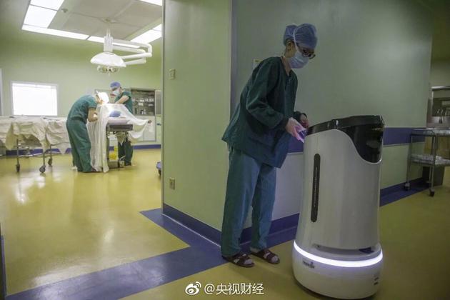△2018年4月2日，广东省第二人民医院手术室的过道上，智能物流机器人“小易”为一台正在进行的手术运送手术器械。/视觉中国