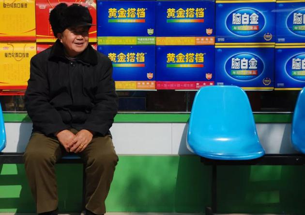 2011年2月2日，湖南邵阳，脑白金等滋补品店前，一位老人在等老伴一起去买脑白金。/图虫创意