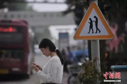 资料图:重庆一红绿灯处摆放“不做低头族、关注红绿灯”警示牌。 陈超 摄