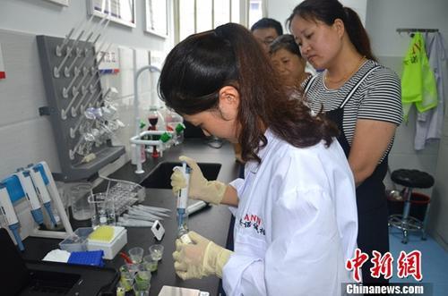 资料图:工作人员根据消费者要求现场检验,共筑食品安全。中新社记者 韩苏原 摄