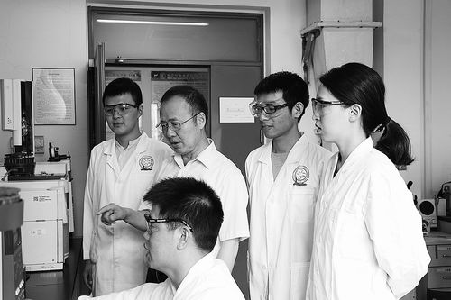 周其林院士(后排左二)在指导学生做实验。