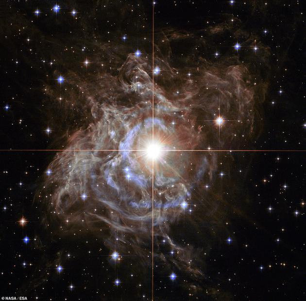 美国宇航局表示,一颗叫做RS船尾座(RS Puppis)的巨大恒星位于花环结构中心区域,它的质量是太阳的10倍,体积是太阳的200倍,其四周形成一圈明亮的尘埃。