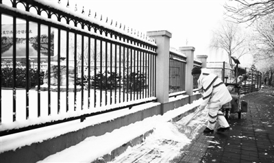 1月5日—6日,北京迎来2020年第一场降雪。图为环卫工人清扫积雪确保市民安全出行。本报记者 周维海摄
