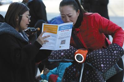 昨日,工作人员在介绍电动车临时标识申请流程。