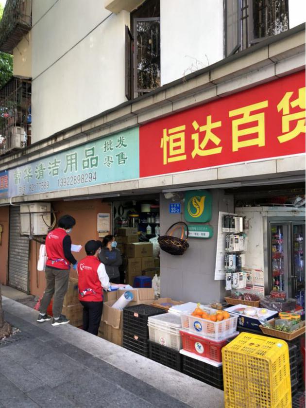 ▲街道办工作人员对商铺进行防控检查
