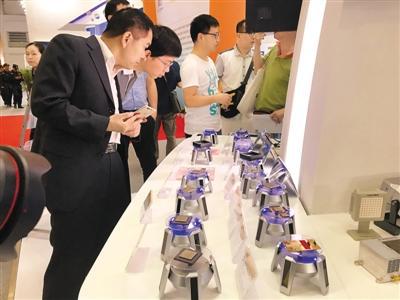 4月24日,在首届数字中国建设成果展览会上,观众参观中国电科展出的芯片。本报记者 王 萌摄