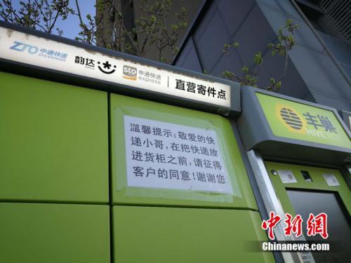 北京市某小区外的快递柜上张贴提示,提醒快递员放进货柜前首先征得收件人同意。中新网 邱宇 摄