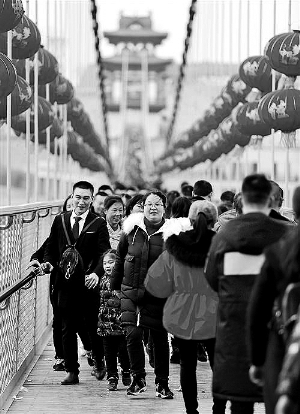 2月18日，四川南充市嘉陵区天乐谷景区孝心桥，游客参加踩桥民俗游。
