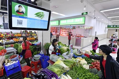 资料图片:2017年11月29日,在合肥瑶海区胜利智能农贸市场,市民在扫码支付。新华社发