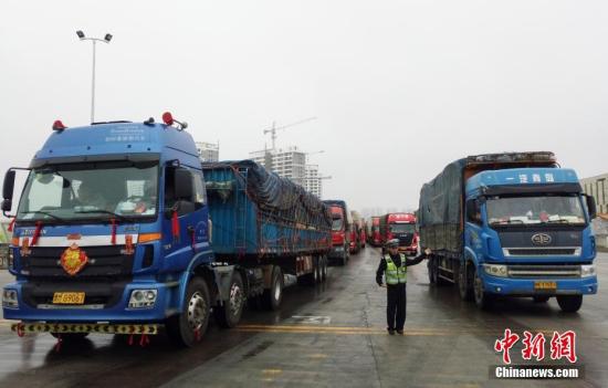 2月23日，海南海口，执勤人员在海口新海港指挥车辆进港。中新社记者 尹海明 摄