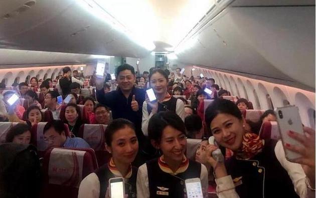 1月17日21:36,在从海口飞往北京的海南航空HU7781次航班上,旅客和空姐在空中使用手机。该航班是国内首个实现手机解禁的航班(海航供图)