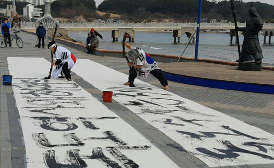  21日，韩国浦项有书法家在路边写毛笔字，强调独岛是韩国领土