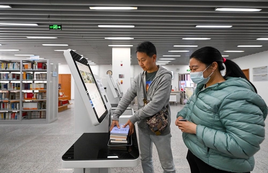↑ 4月21日，在天津市河西区文化中心，读者在区文化中心图书馆进行图书通借通还。