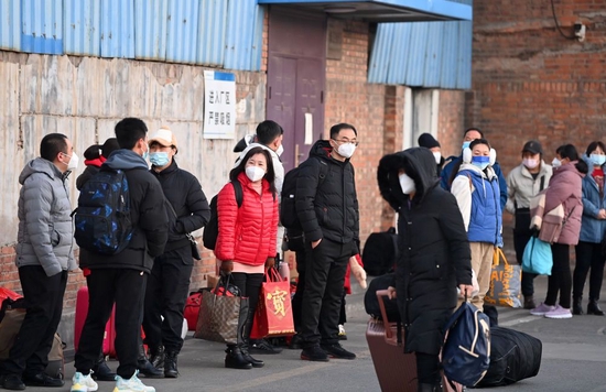 ↑1月16日，返乡工人在天津市北辰区宜兴埠镇等待车辆到达。