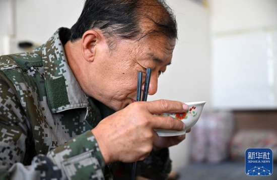 6月2日,朱金保在八仙山聚仙峰峰顶的森林防火管理站内吃早餐。