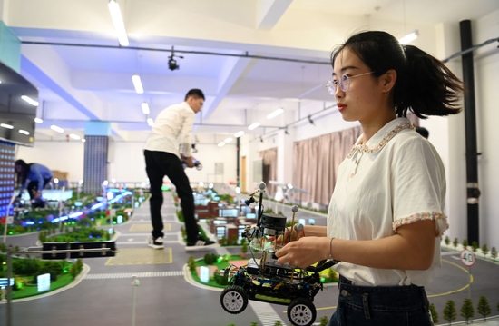 天津大学智能与计算学部的学生在沙盘教室内调试车辆模型。 新华社记者 李然 摄