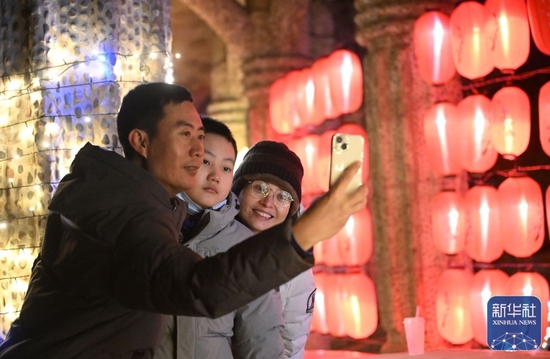 ↑游客在中华石园新春民俗灯会拍照留念（1月26日摄）。
