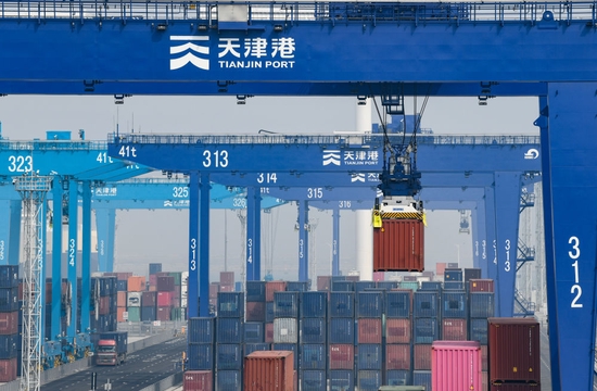 ↑4月9日，在天津港北疆港區C段智能化集裝箱碼頭，場橋在堆場內吊運集裝箱。