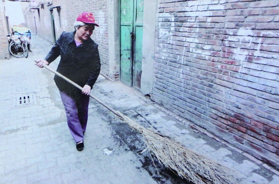 孙丽华正在清扫街道。（天津市总工会供图）