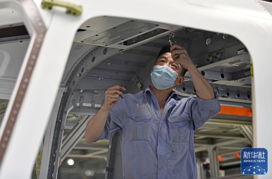 5月19日,在中国航空工业集团天津直升机有限责任公司车间内,工作人员在进行AC332民用直升机的铆接作业。新华社记者赵子硕摄